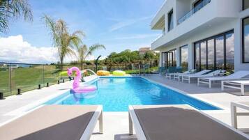 A modern pool area with lounge chairs and a swan float.