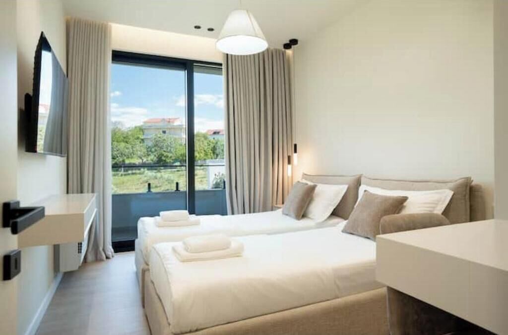A hotel room with a bed, a desk, and a TV.