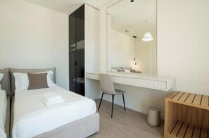 A modern hotel room with a bed, a desk, a chair, and a mirror. - Luxury Villa with swimming pool, jacuzzi,breathtaking views. (Rrashbull)