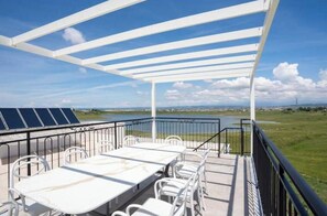 A covered outdoor area with a table and chairs, overlooking a body of water and distant landscape. - Luxury Villa with swimming pool, jacuzzi,breathtaking views. (Rrashbull)