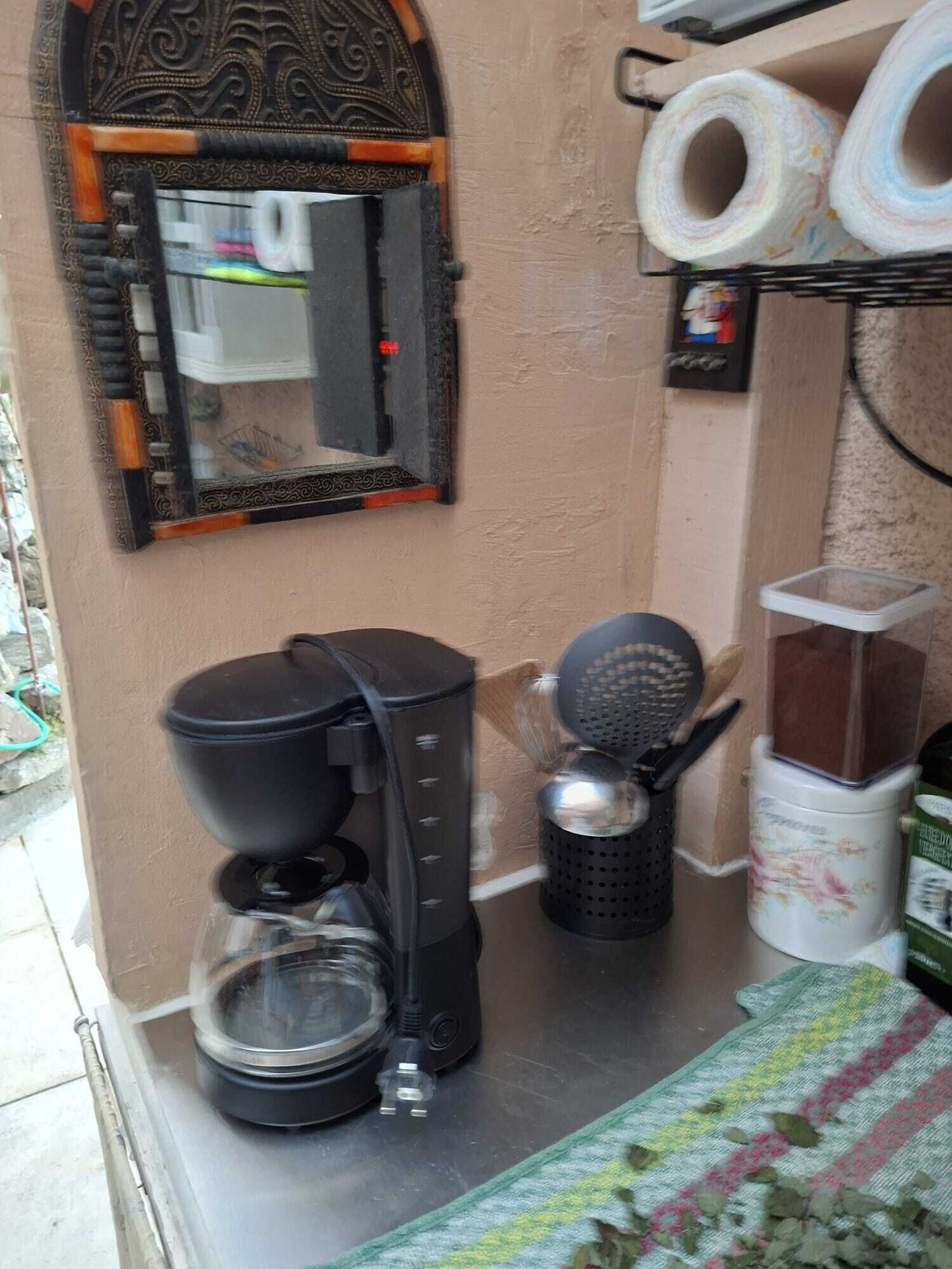 Eine Küchenzeile mit Kaffeemaschine, Mixer und Wasserkocher auf einer Arbeitsplatte.