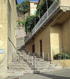 A narrow stairway leading to a building with a metal railing and a sign reading 'AEROSININE'. - A haven of peace—the perfect starting point for exploring the untamed beauty of the Corsican valleys. (Moltifao)