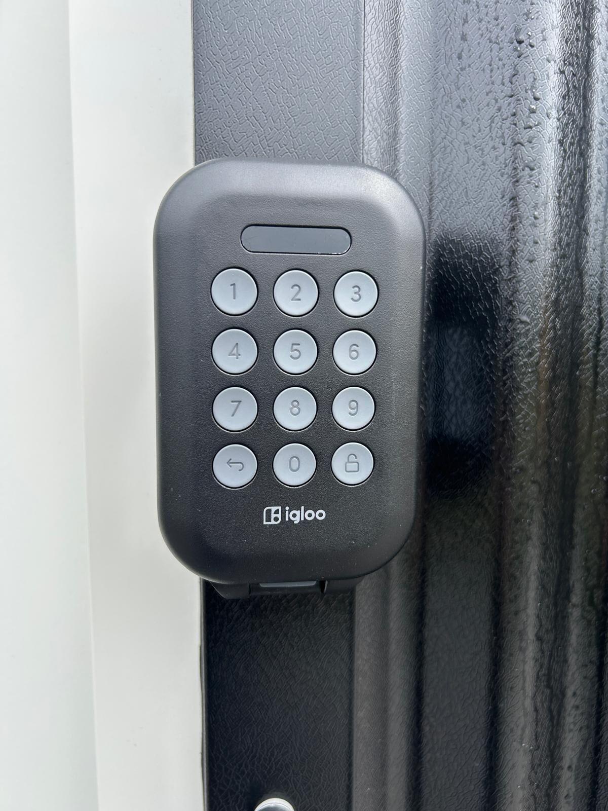 A black electronic keypad lock on a door.