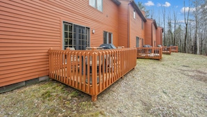 Ett tvåvåningshus med en träveranda och en täckt uteplats.