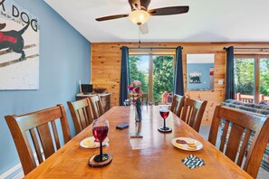 A dining area with a wooden table, chairs, and a ceiling fan. - Indoor Pool + Fireplaces + Game Room | Gore Mtn NY | The Summit at Gore (North Creek)