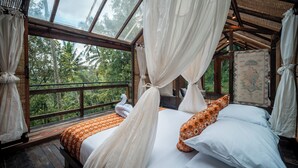 Una habitación con cama, cortinas y vistas al exterior.