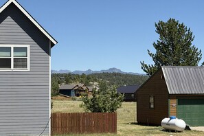 A residential area with a house, a wooden fence, and a green garage door. - Fall Escape Special: 15% Discount Ends Nov 30! Must book by Oct 18 (Pagosa Springs)