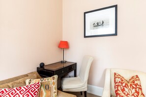 A room with a desk, chair, and a framed picture on the wall. - Charming Two-Bed in South Kensington (London)