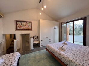 A bedroom with a bed, a chair, a wardrobe, a painting, and a staircase. - Villa Renetta Rapallo (Rapallo)