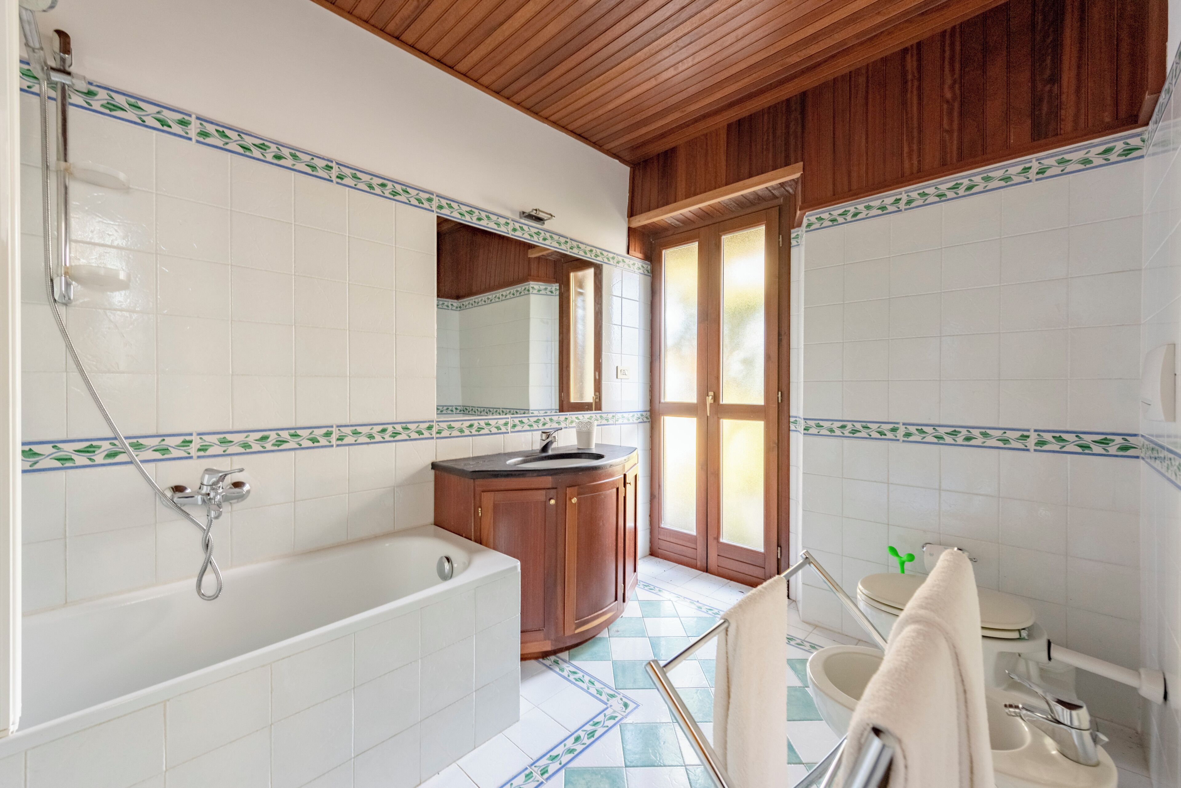 Ein Badezimmer mit Badewanne, Waschbecken, Toilette und Holzboden.