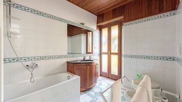 Ein Badezimmer mit Badewanne, Waschbecken, Toilette und Holzboden.