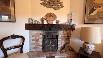 A fireplace with decorative items, a chair, and a lamp.