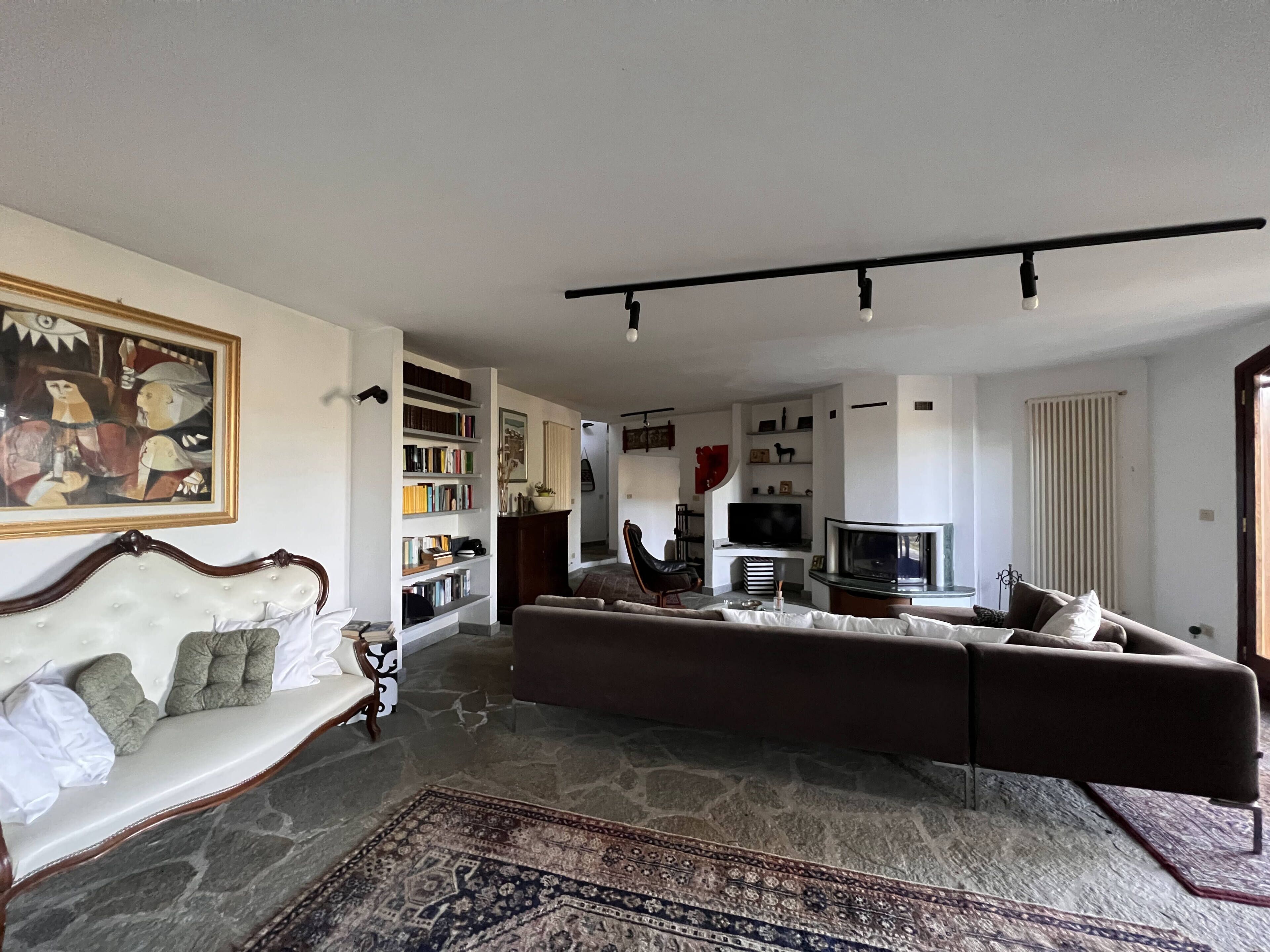 A living room with a sofa, a television, and a bookshelf.