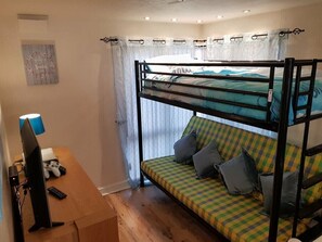 A bunk bed with a checkered mattress, a desk with a computer and a lamp, and a window with curtains. - Cala Gran Holiday Park - Holiday Accommodation 7934 (Fleetwood)