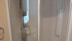 A bathroom with a glass shower enclosure, a sink, and a toilet. - Cala Gran Holiday Park - Holiday Accommodation 9468 (Fleetwood)