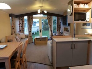 A compact living space with a dining area, kitchenette, and a view of the outdoors. - Cala Gran Holiday Park - Holiday Accommodation 9468 (Fleetwood)