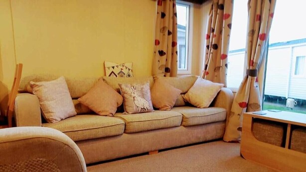 A living room with a sofa, a chair, and a wooden coffee table. - Cala Gran Holiday Park - Holiday Accommodation 9468 (Fleetwood)