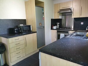 A kitchen with a microwave, refrigerator, stove, and cabinets. - Cala Gran Holiday Park - Holiday Accommodation 9426 (Fleetwood)