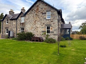 A stone house with a sloped roof, a small front yard, and a wooden fence. - Tigh na Sithe, Traditional Victorian Villa (Perth and Kinross)