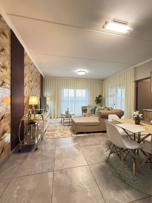 A modern living room with a sofa, a dining table, and a lamp. - Waterfall Executive suite (Midrand)