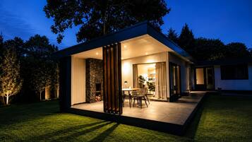 A modern house with a patio area, a fireplace, and a dining set.