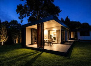 Uma casa moderna com um espaço de pátio, lareira e conjunto de jantar.