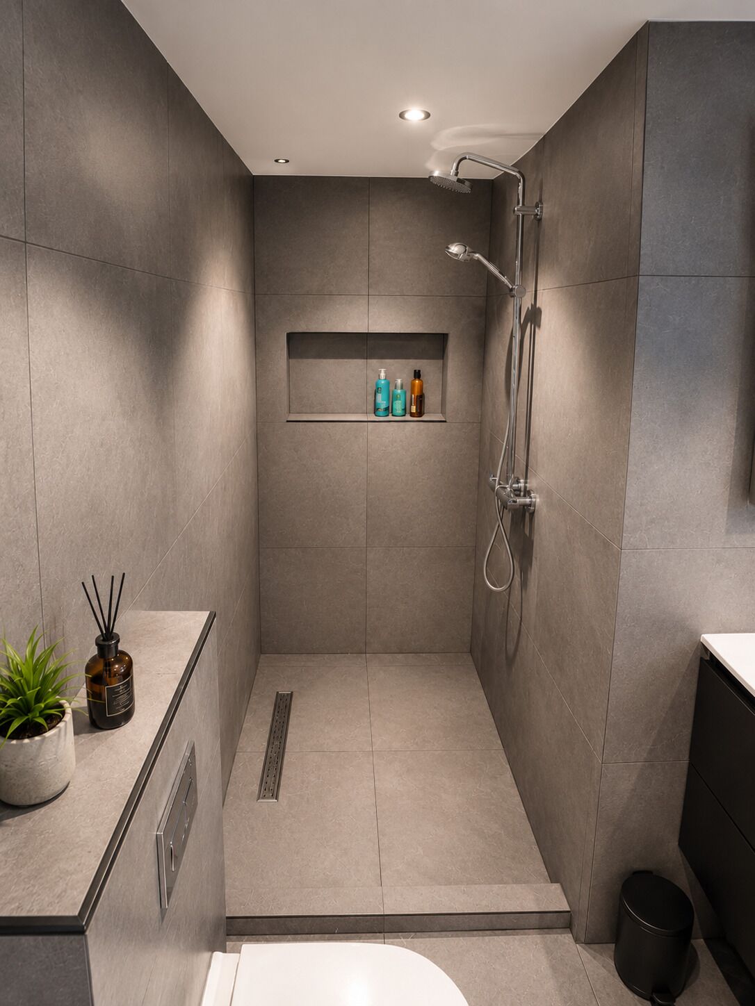 Une douche moderne dotée d’un pommeau de douche à main et d’un robinet mural.