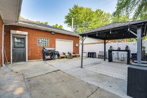 A brick house with a garage, outdoor seating, and a covered patio area. - Near Parks & Eats! Elegant Southwest Chicago Home (Chicago)