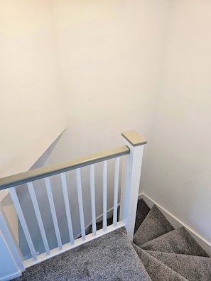A staircase with a white railing and carpeted steps. - The Chilux stylish apartment (Rainham)