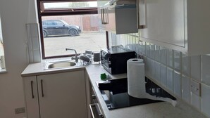 Moderni keittiö, jossa on ikkuna, pesuallas ja työtaso.