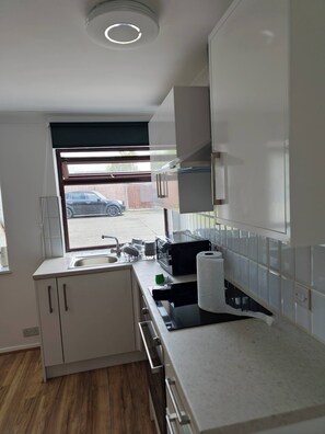 A modern kitchen with a window, a sink, and a countertop. - The Chilux stylish apartment (Rainham)