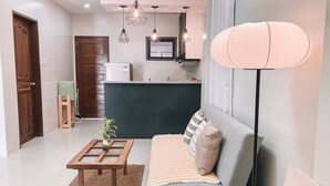 Uma sala de estar com sofá, mesa de centro e abajur.