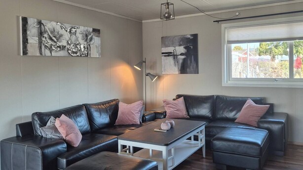 Una sala moderna con un sofá modular, un reposapiés y una mesa de centro.