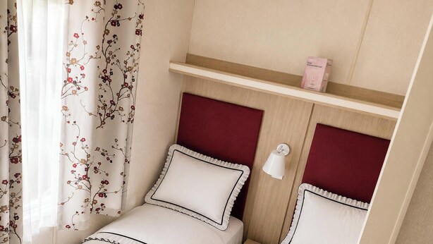 A bedroom with a single bed, a nightstand, a shelf with a box, and a wall-mounted lamp. - MKRJ LUXURY PLUS – Sleeps 8 - Pet Friendly - LARGE En-suite- mp619 (Camber)