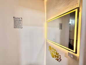 A hallway with a mirror, a wall-mounted sign, and a decorative pattern. - Full private house in heart of Pattaya, 2 min to beach (Pattaya City)
