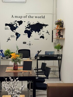 A room with a world map on the wall, a desk with a laptop, a chair, and a small shelf with decorative items. - Full private house in heart of Pattaya, 2 min to beach (Pattaya City)