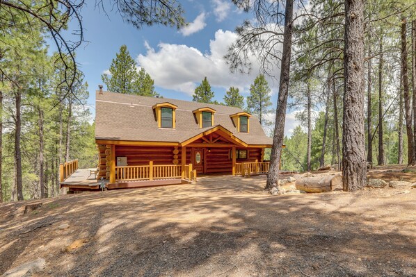 A log cabin with a porch, a chimney, and a deck. - Real Log Cabin in Flagstaff with Forest Views (Flagstaff)