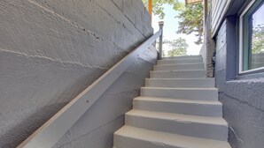 A set of white stairs with a handrail leading to a window.