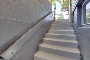 A set of white stairs with a handrail leading to a window.