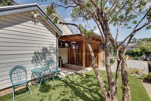 A house with a covered porch, two outdoor chairs, a tree, and a bicycle in the background. - Walk to SSU & Shakespeare Fest! Colorful Retreat (Cedar City)