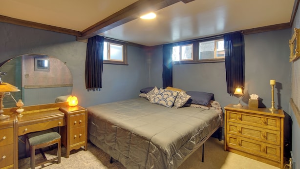 A bedroom with a bed, a dresser, a desk, and a chair.