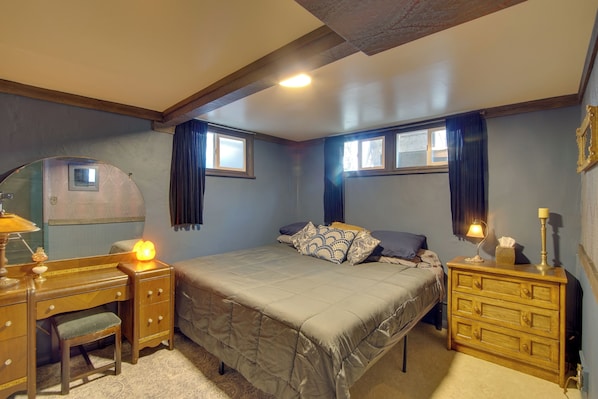 A bedroom with a bed, a dresser, a desk, and a chair.