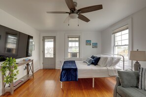 A bedroom with a bed, bedside table, ceiling fan, windows, and a door. - 5 Blocks to Sand! Pet-Friendly Unit in Ocean Grove (Ocean Grove)