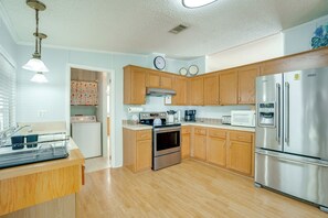 A kitchen with wooden cabinets, stainless steel appliances, a built-in oven, and a microwave. - Active-Adult Community! Port Charlotte Home, Lanai (Port Charlotte)