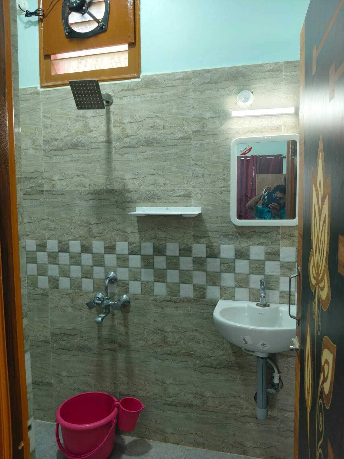 Un baño con ducha, lavamanos y espejo.