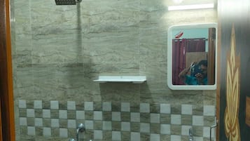 Un baño con ducha, lavamanos y espejo.