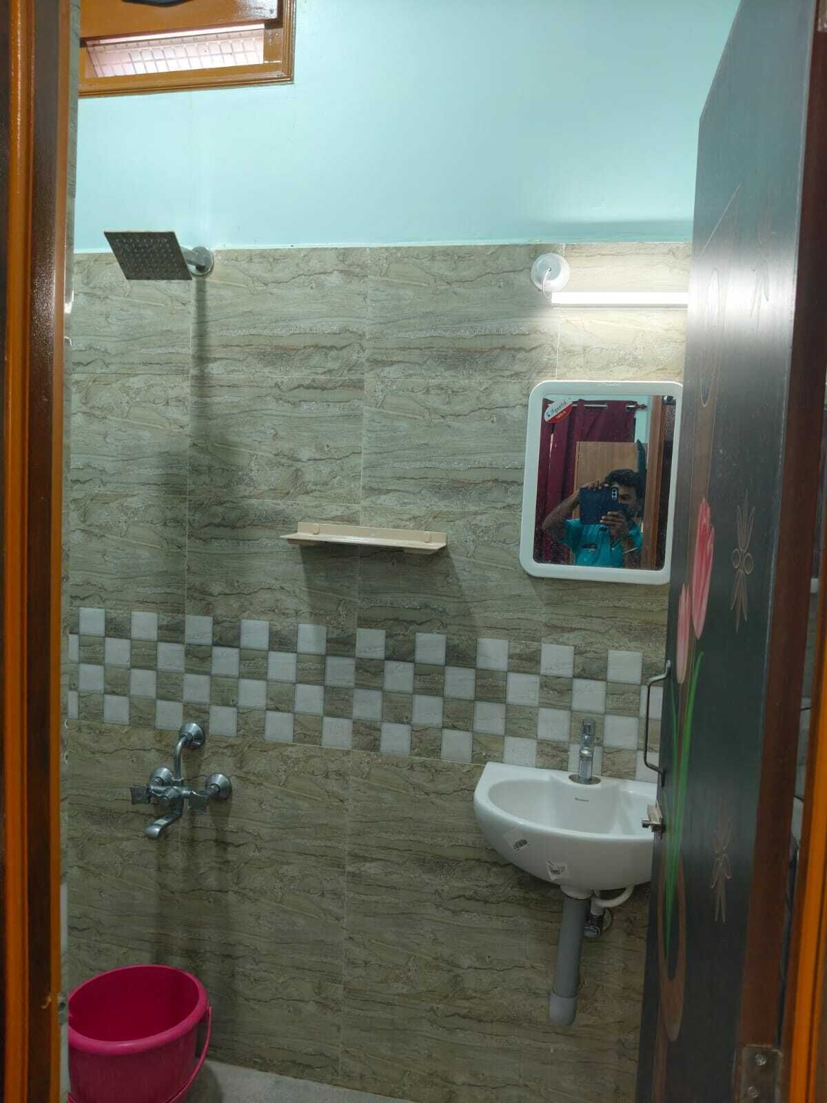 Un baño con ducha, lavamanos y espejo.