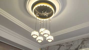 A ceiling with a circular light fixture and hanging spherical lights.