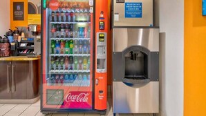 Máquina expendedora con logotipo de Coca-Cola y dispensador de agua.