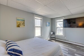 A hotel room with a bed, a chair, a TV, and artwork on the walls. - Walk to Beach, Boardwalk, Restaurants: Asbury Park (Ocean Grove)